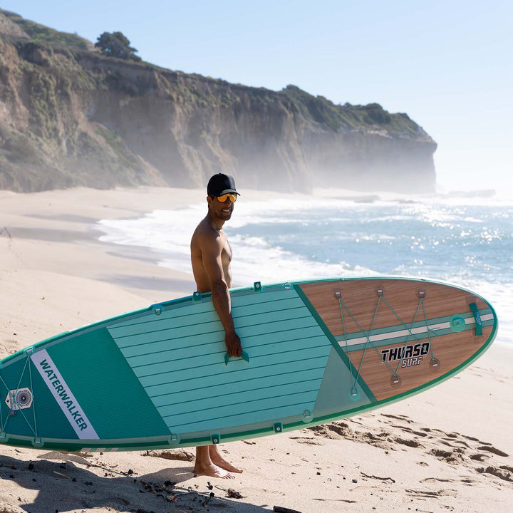 man carrying waterwalker 132 turquoise sup paddle board