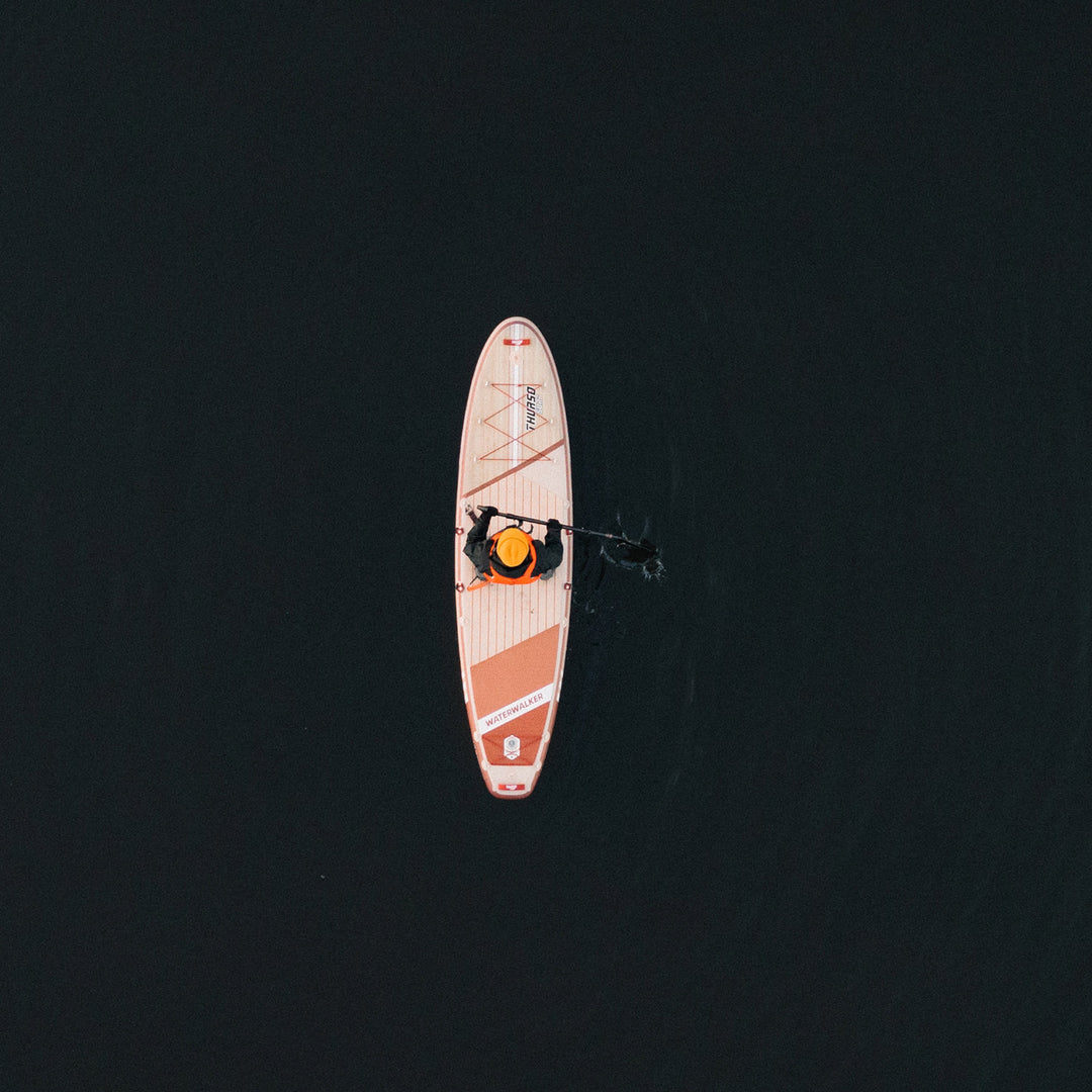 man paddling on Waterwalker 132 crimson paddle board drone shot from top
