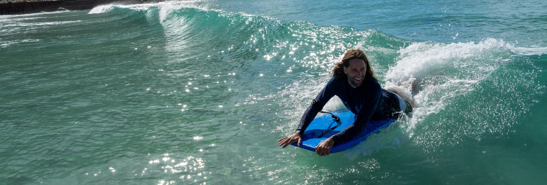 Person surfing on a blue wave in the ocean