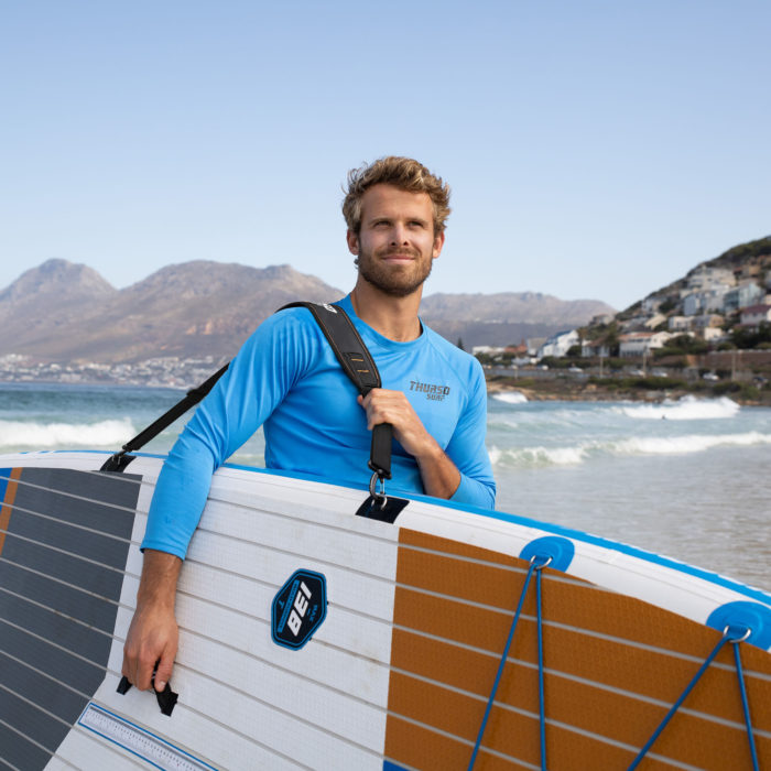 man carrying paddle board with a shoulder strap carrier thurso surf