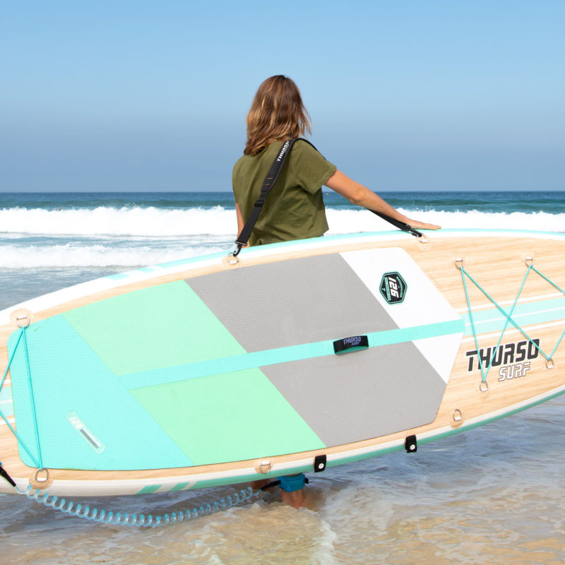 woman carrying paddle board with a shoulder strap carrier thurso surf